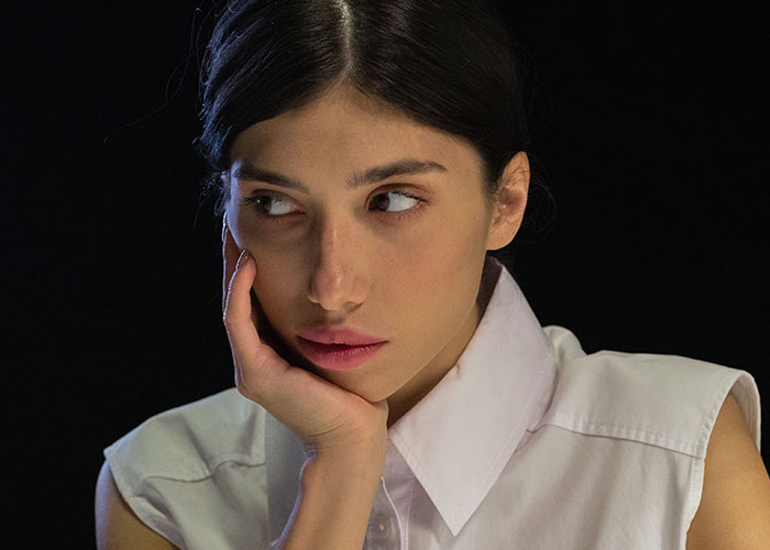 A thoughtful woman looking to the side, symbolizing a woman discovering her soulmate cheating.