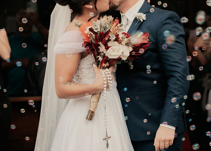A bride and groom kiss, surrounded by bubbles, highlighting the contrast between wedding vows and women catching cheating partners.