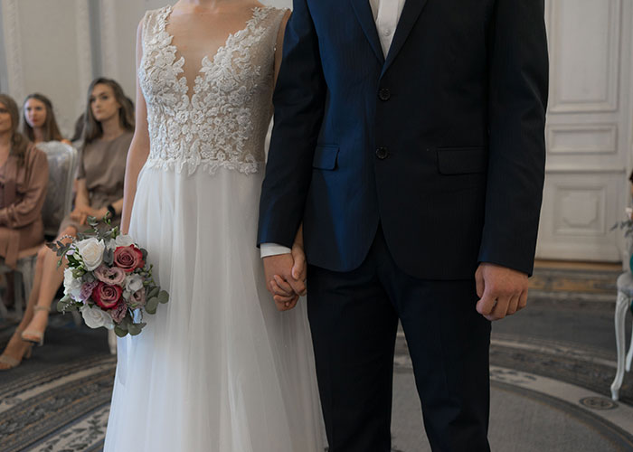 A bride and groom holding hands, representing women finding their soulmates cheating.