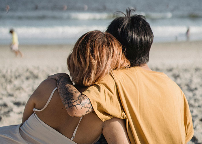 A couple embraces on a beach, representing soulmates and the ways women caught their partners cheating.