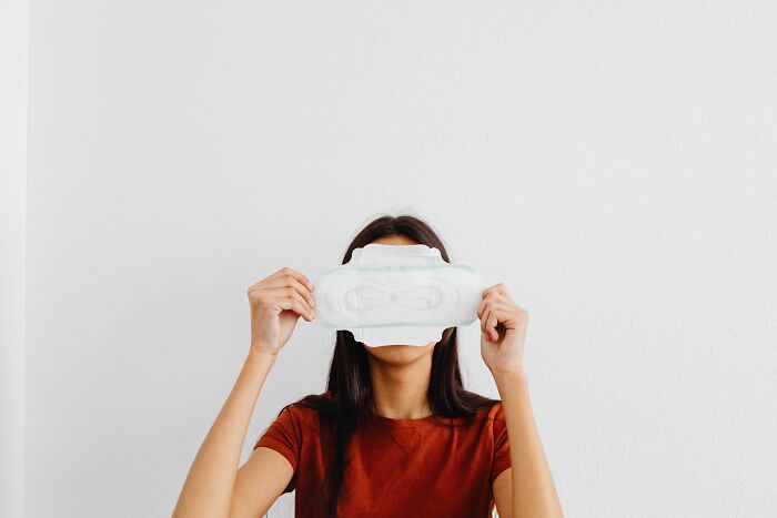 A woman holds a sanitary pad over her eyes, representing discussions about unhinged things doctors say.