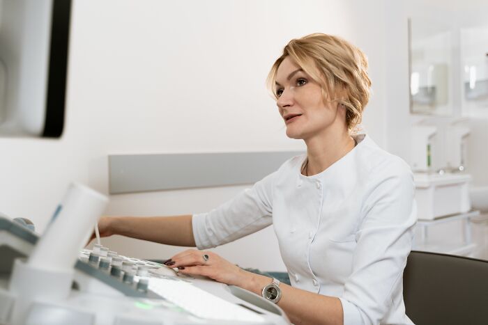 A female doctor in a white coat operating an ultrasound machine, highlighting things doctors said.