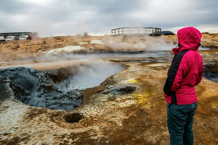 A person in a red jacket looking at a steaming geothermal area, highlighting things doctors said.