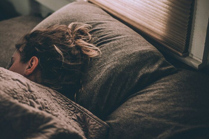A person sleeping soundly on a pillow, oblivious to potential strange experiences, making others shiver.