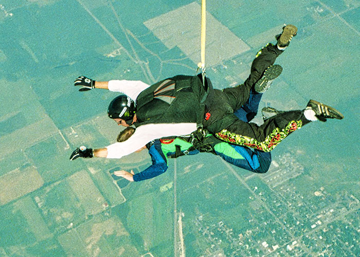 Two people skydiving, an adventurous activity often associated with a cringe midlife crisis.