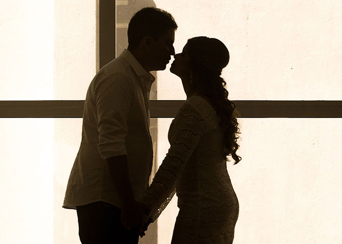 A silhouette of two people about to kiss, capturing a romantic moment that could be a cringe midlife crisis.