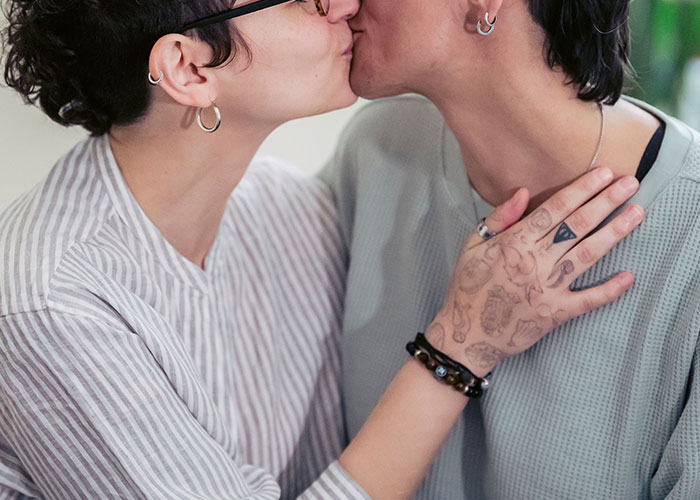 Two people share a kiss, illustrating a moment that could be part of a cringe midlife crisis.