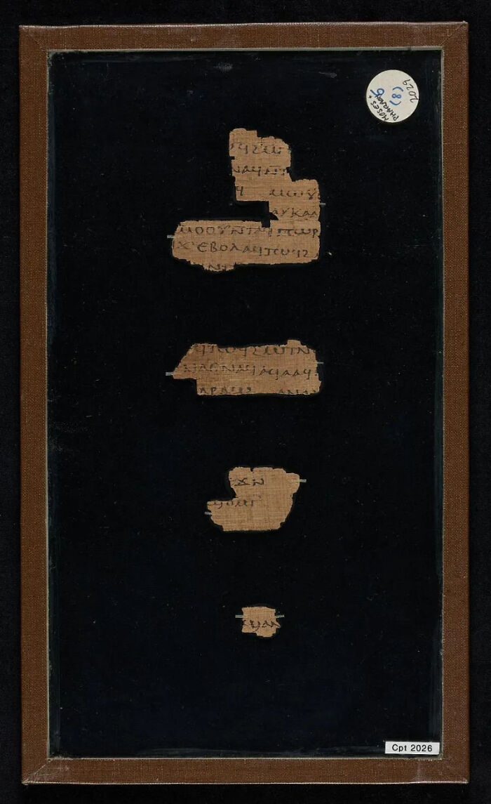 A dark background highlighting fragmented historical documents or manuscripts, showing ancient texts.