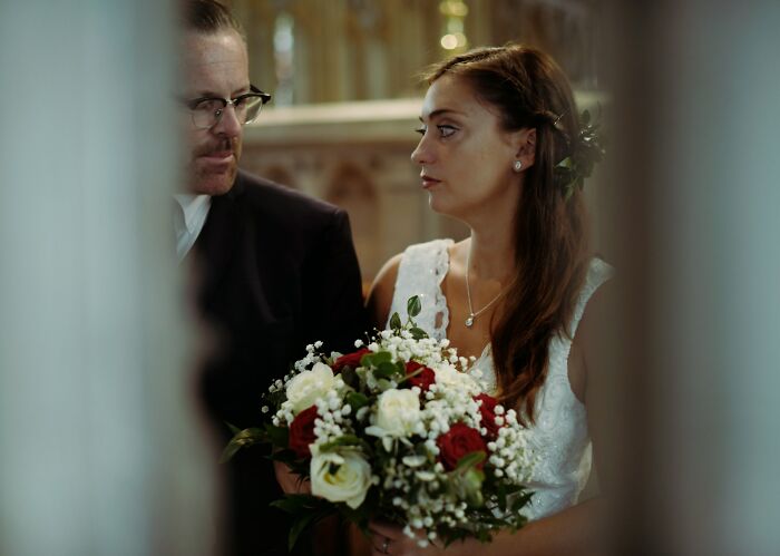 A worried bride holding a bouquet, representing a stressful wedding moment.