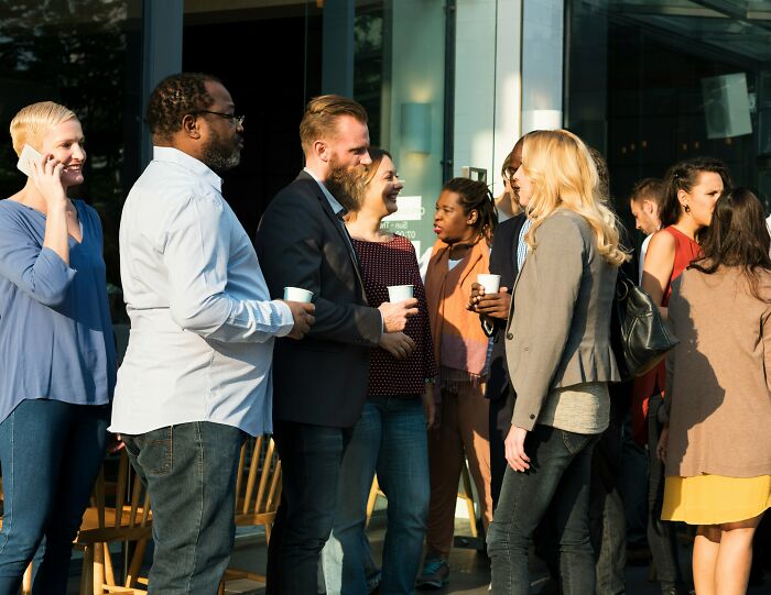 A group of newcomers in America chatting happily, experiencing American culture for the first time.