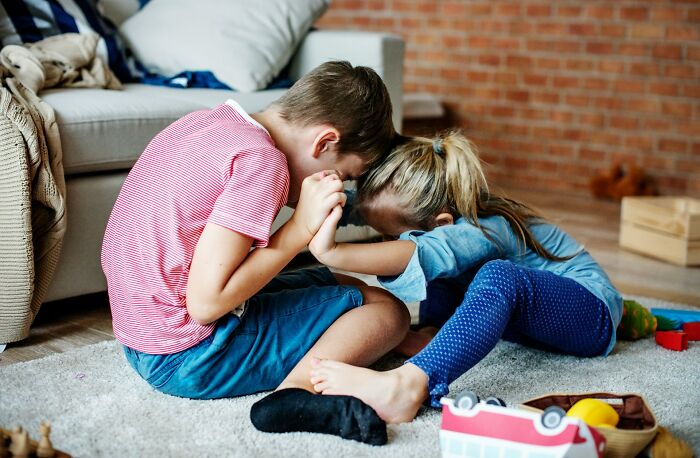 Two young siblings sitting on a rug and playing, depicting the experiences of being married.