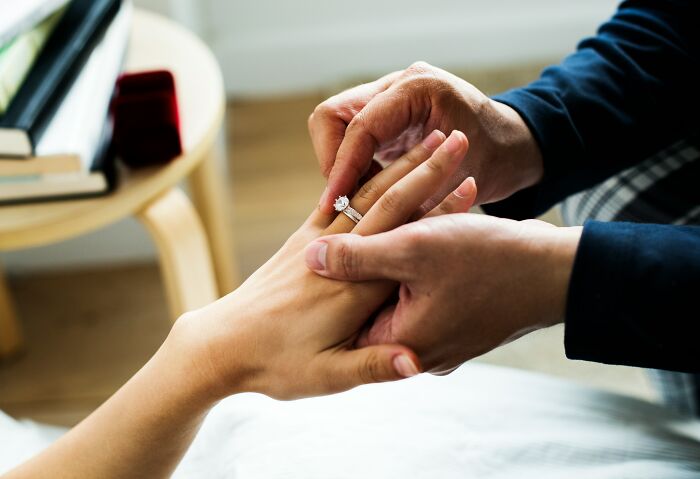 A man puts a ring on a womans finger, symbolizing commitment and the importance of recognizing relationship red flags for mental health.