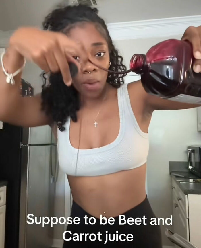 A woman pouring red liquid, labeled as beet and carrot juice, from a bottle, exposing fake foods Americans eat. A woman pouring red liquid, labeled as beet and carrot juice, from a bottle, exposing fake foods Americans eat.