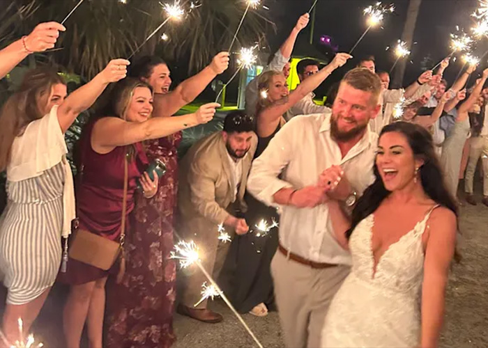 A happy bride and groom with guests holding sparklers, symbolizing life before the tragic drunken daughter incident. A happy bride and groom with guests holding sparklers, symbolizing life before the tragic drunken daughter incident.