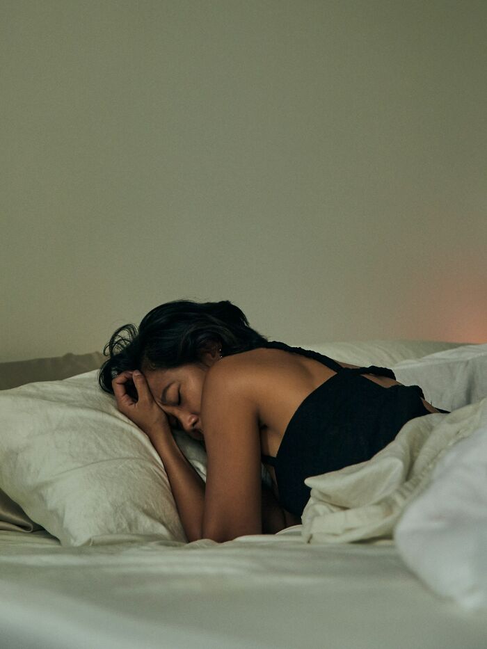 A woman sleeping in bed, possibly dreaming of creepy true stories that question reality.