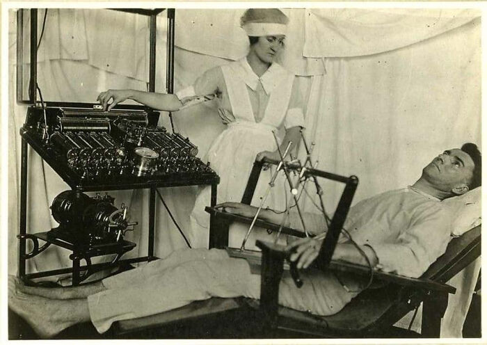 A nurse monitors a patient receiving terrifying medical treatment with numerous wired instruments and tools.