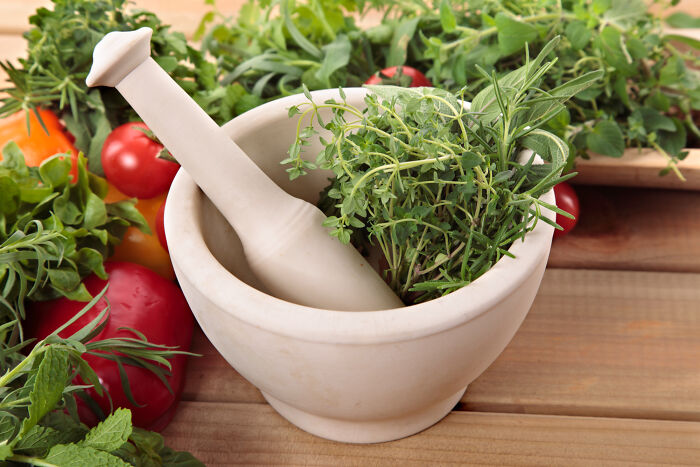 A mortar and pestle with fresh herbs, representing natural remedies, contrasting with things patients have said to doctors.