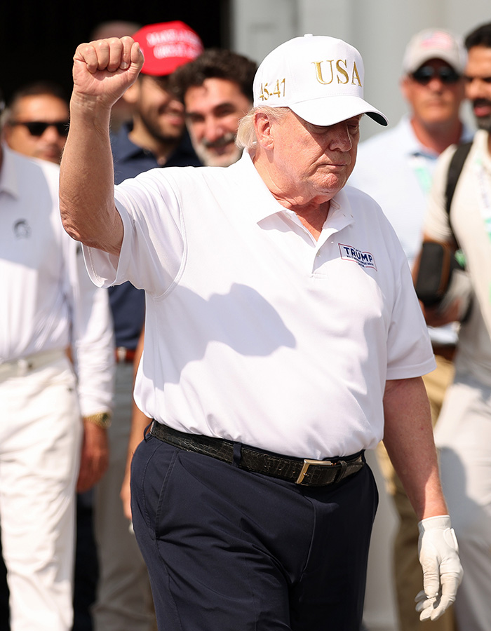 Donald Trump wearing a white USA cap, clenching his fist, showing a health marker in his physical appearance. Donald Trump wearing a white USA cap, clenching his fist, showing a health marker in his physical appearance.