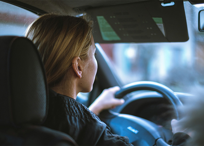Woman driving a car, demonstrating how a hair accessory can cause injuries during an accident.
