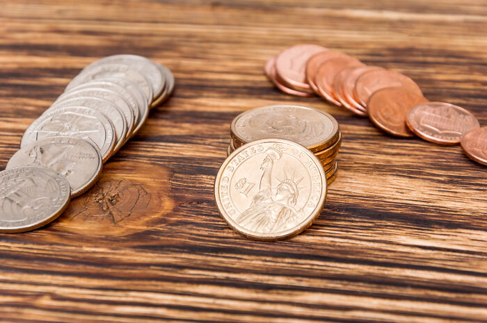 Coins and money on a wooden table, representing the real deals and financial signs from the universe.