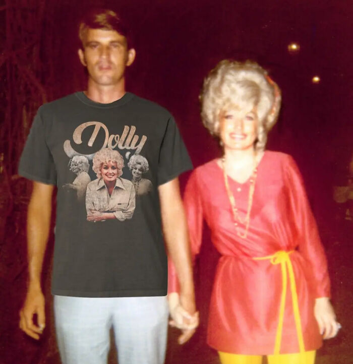 A man wearing a Dolly Parton t-shirt stands next to a woman in a red outfit, highlighting Dolly Parton's selfless offer. A man wearing a Dolly Parton t-shirt stands next to a woman in a red outfit, highlighting Dolly Parton's selfless offer.