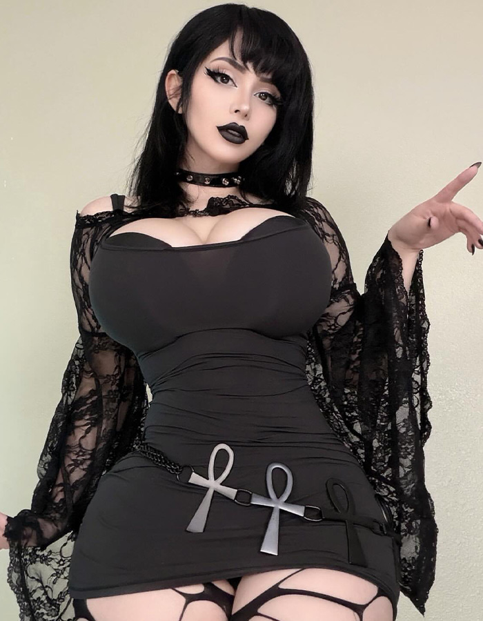 Drake’s Goth Baddie in a black lace dress with ankh belt, full-body shot. Drake’s Goth Baddie in a black lace dress with ankh belt, full-body shot.