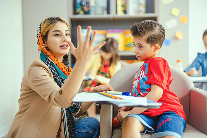 A babysitter counting on fingers to a young boy, illustrating the problem with a crying baby. A babysitter counting on fingers to a young boy, illustrating the problem with a crying baby.