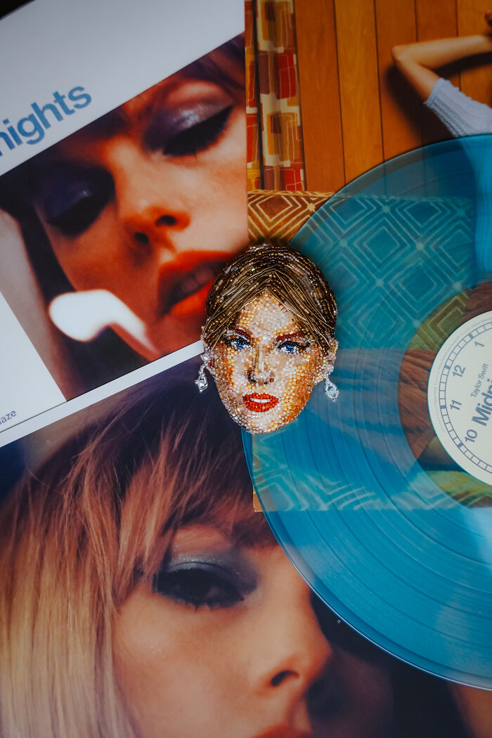 A detailed beaded creation by Tiffany Pisani, capturing a female face, alongside a blue vinyl record and album art.