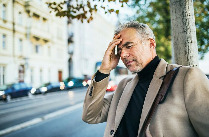 A man with a pained expression on a city street, reminding Americans to be respectful when they visit other countries.