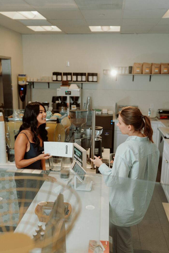 An American tourist being respectful while ordering coffee from a barista in a foreign country.