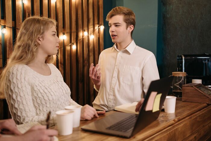 Two young Americans talking at a cafe, highlighting the need for Americans to be respectful when they visit other countries.