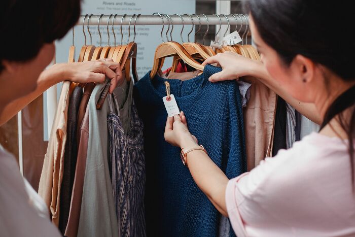 Two women shopping for clothes, highlighting the price differences and pink taxes women face.
