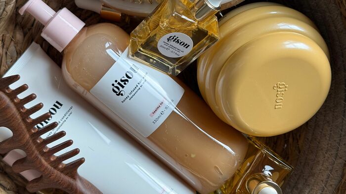 Hair care products from Gisou in a basket, representing the cost burden of pink taxes on women.