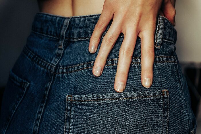 A hand in the back pocket of blue jeans, representing how pink taxes make being a woman more difficult.
