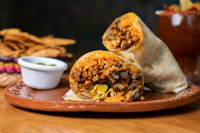 A delicious burrito cut in half, symbolizing the everyday expenses that contribute to pink taxes.