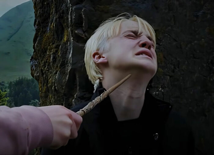 Draco Malfoy in a scene from Harry Potter, with a wand pointed at his throat. Draco Malfoy in a scene from Harry Potter, with a wand pointed at his throat.