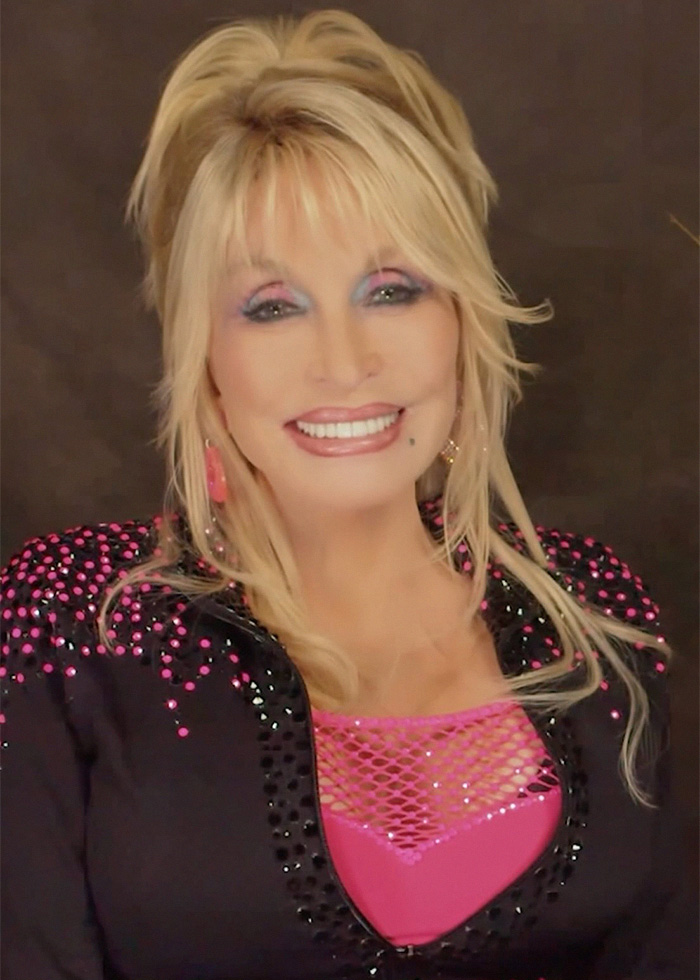 Dolly Parton smiles, wearing a black top with pink sequins, showing support and a sweet letter to Eminem.