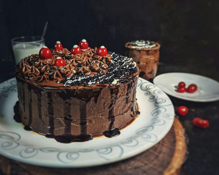Chocolate cake with cherries and frosting, a sweet treat for customer interactions in retail.