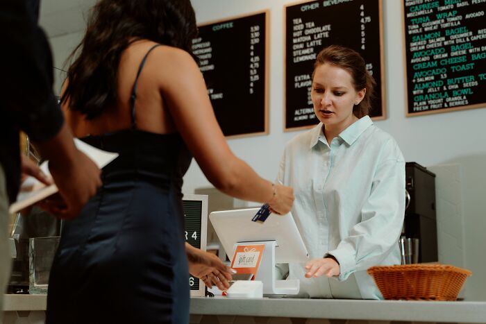 Retail worker assisting a customer at a counter, reflecting typical customer interactions.