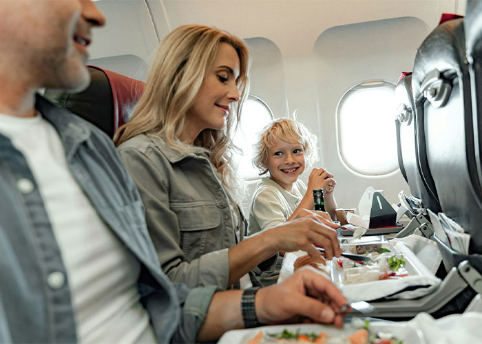 A happy family, a mom and her kid, enjoy a plane seat and plane food. A happy family, a mom and her kid, enjoy a plane seat and plane food.