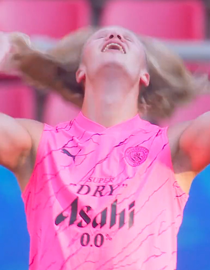 Erling Haaland celebrating in a pink jersey, his blond locks flowing before his new haircut. Erling Haaland celebrating in a pink jersey, his blond locks flowing before his new haircut.