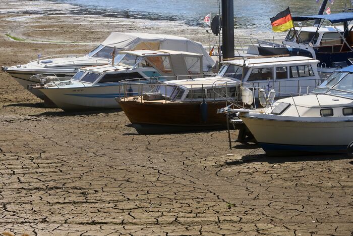 Europe suffers brutal drought: boats stranded on cracked, dry riverbed, unable to sail due to extremely low water.