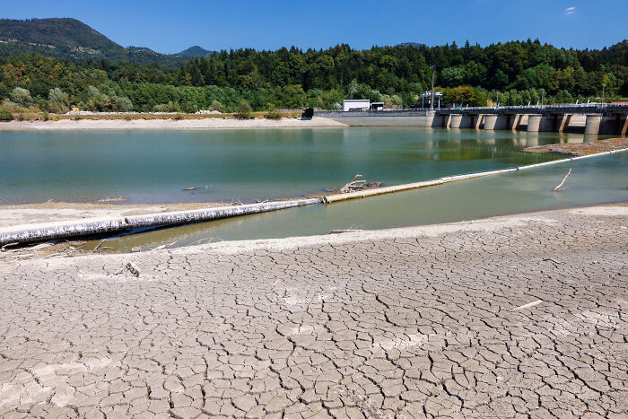 Cracked, dry earth on the shore of a reservoir, showcasing Europe's brutal drought.