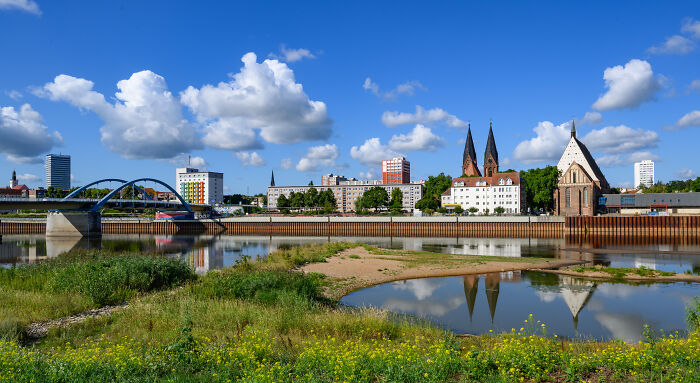 A river with visibly low water levels reflecting the sky, showcasing the effects of Europe's brutal drought.