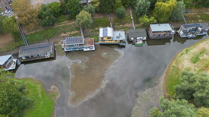 Houseboats in a shallow river, revealing dry riverbed due to Europe's brutal drought.