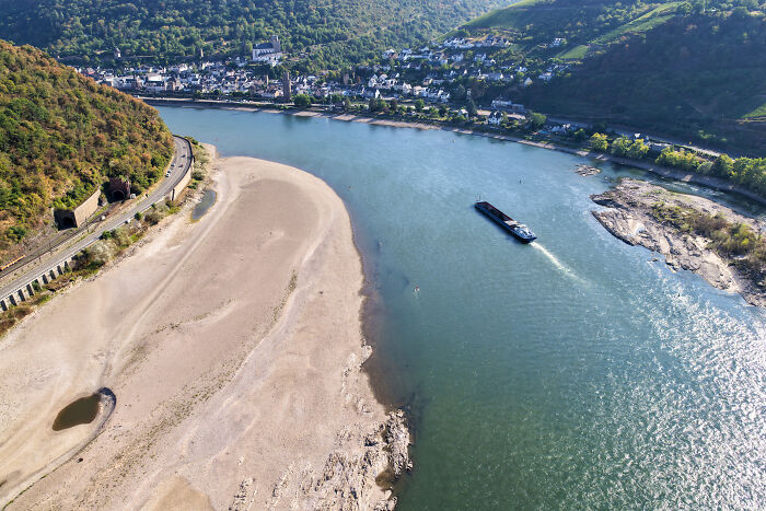 An aerial view of a wide river with significantly exposed riverbanks due to the brutal drought in Europe.