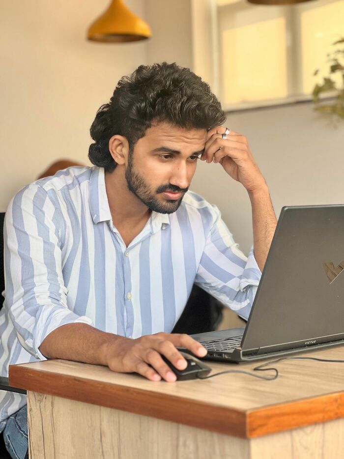 A man looking thoughtfully at his laptop, reflecting on questions Americans asked Europeans.