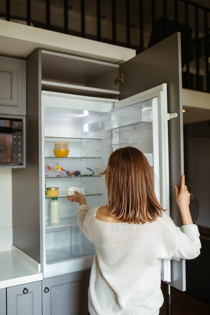 A woman opening a refrigerator, symbolizing the puzzling questions Americans asked Europeans.