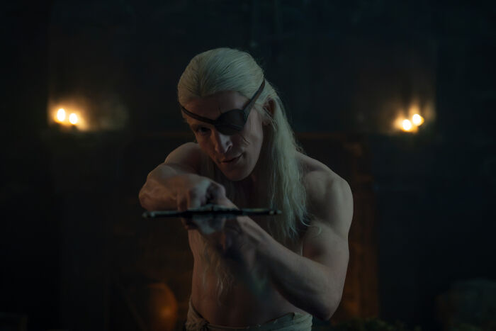 A shirtless character with an eye patch, from House of the Dragon, in a controversial intimate scene. A shirtless character with an eye patch, from House of the Dragon, in a controversial intimate scene.