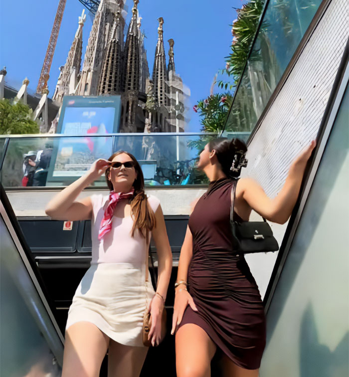 Two women posing on a metro station escalator with a grand building in the background, a scene from the metro station hero video. Two women posing on a metro station escalator with a grand building in the background, a scene from the metro station hero video.